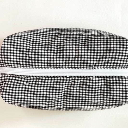 Vista desde arriba del neceser donde se aprecia la amplia apertura de la cremallera de lado a lado del neceser.