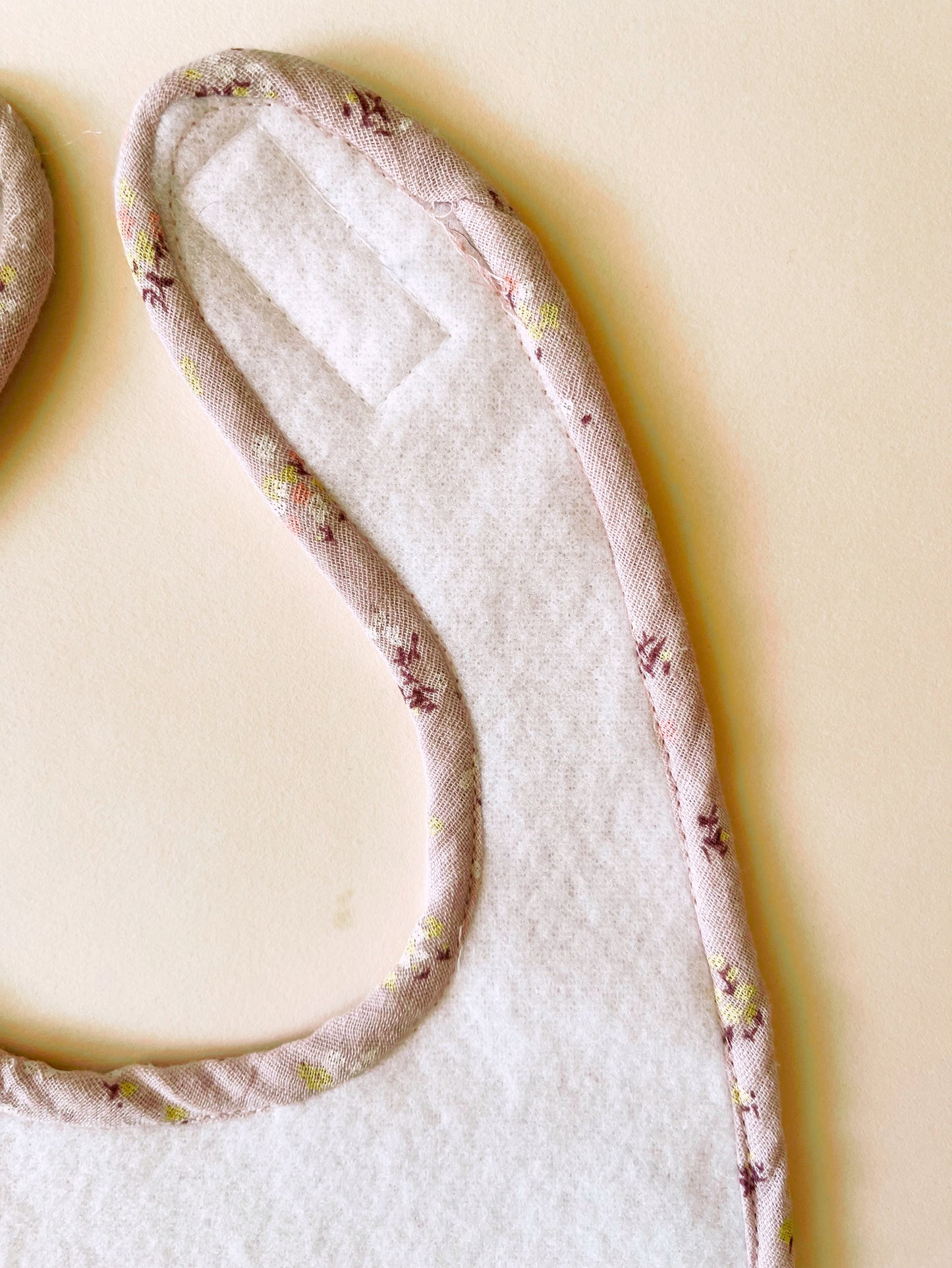 parte trasera del babero  donde se aprecia el cierre en un resistente velcro ajustable al crecimiento del bebé