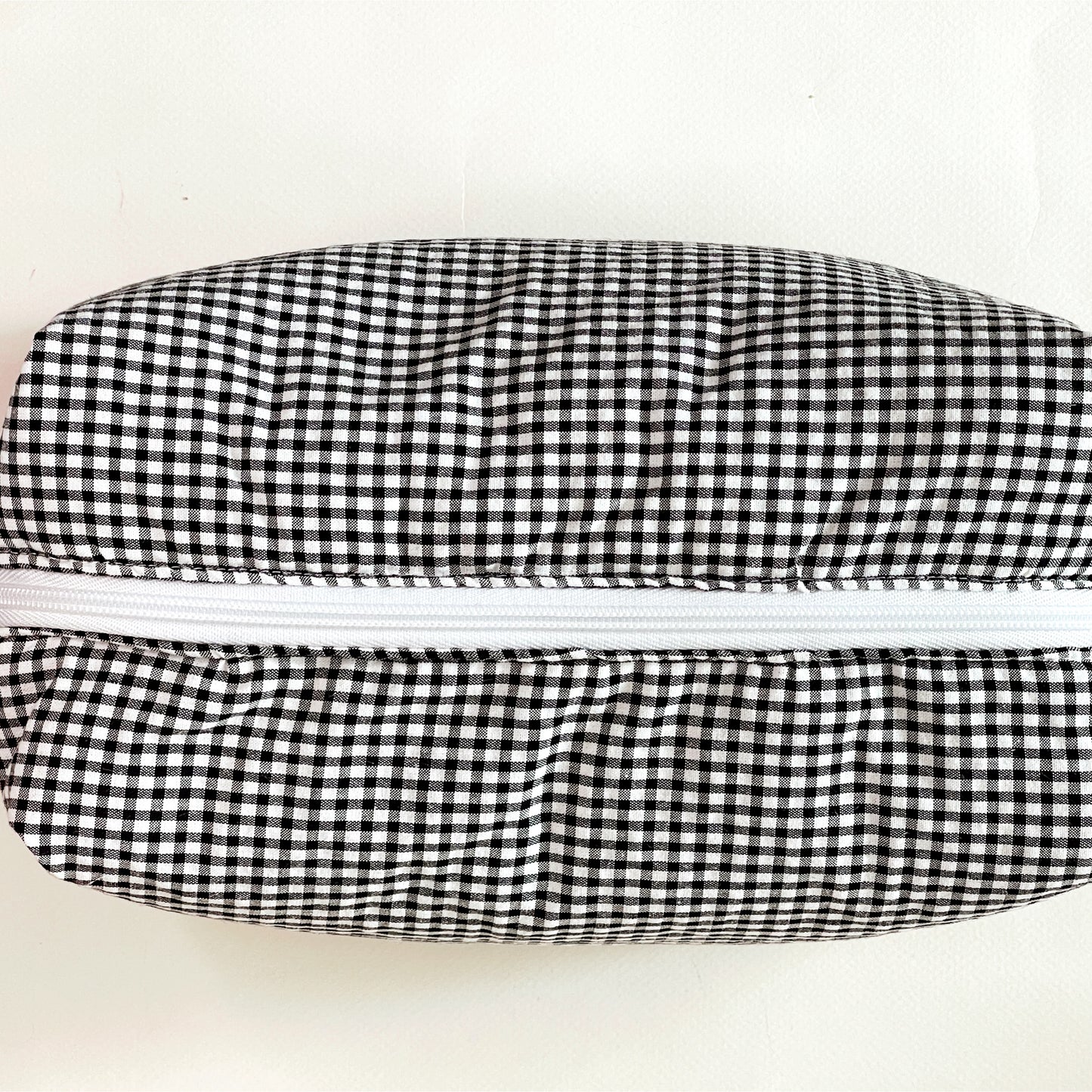 Vista desde arriba del neceser donde se aprecia la amplia apertura de la cremallera de lado a lado del neceser.