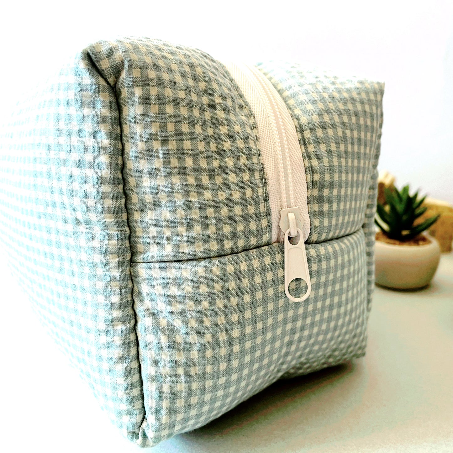 Vista lateral del neceser de estampado cuadros verde menta y blanco, cierre con amplia cremallera