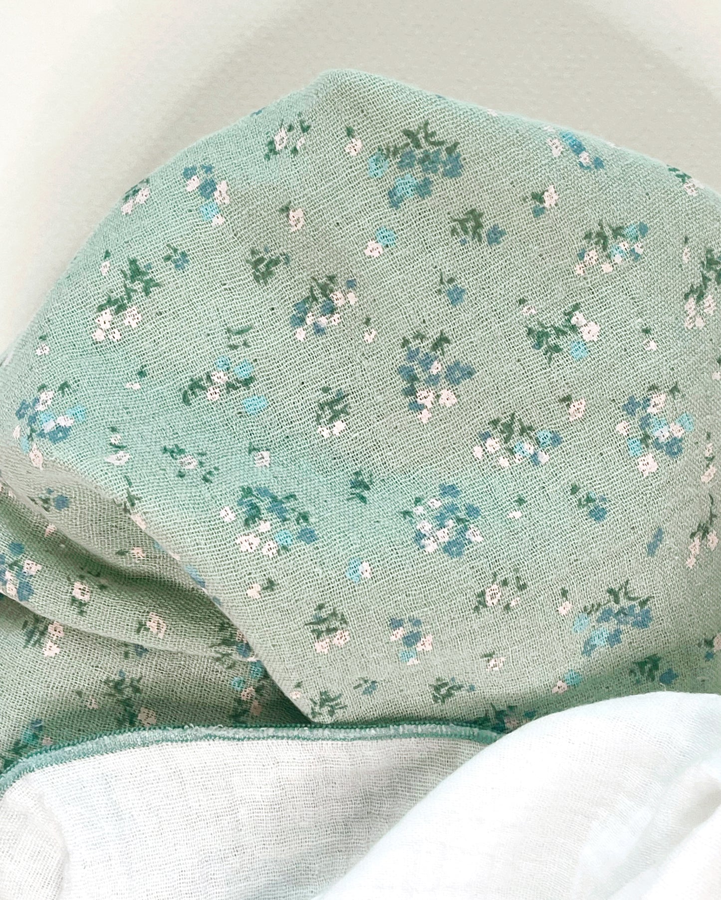 Conjunto de muselina de color verde con flores azules y blancas y muselina en color blanco 