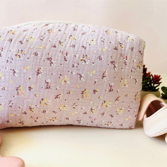 Vista frontal del neceser de muselina con florecitas amarillas y blancas