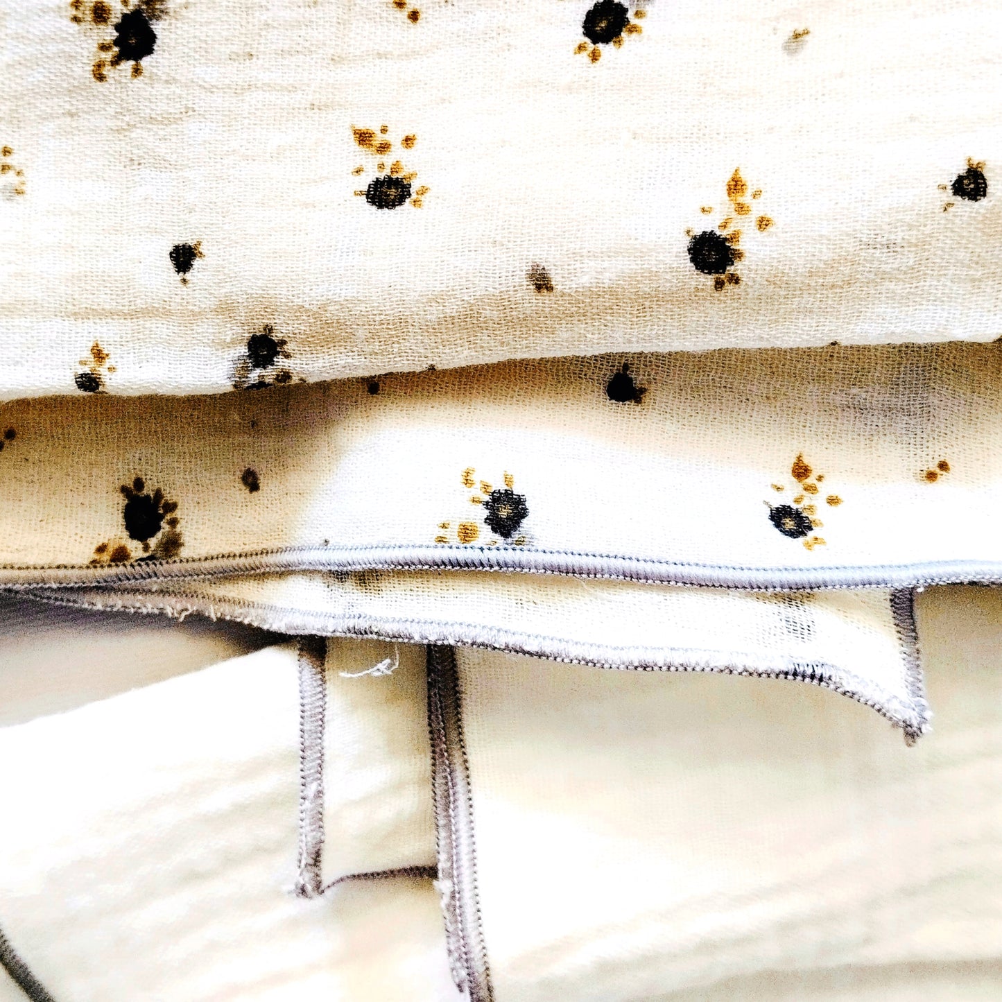 Conjunto de dos muselinas en color beis con flores grises y verdes  y blanco liso