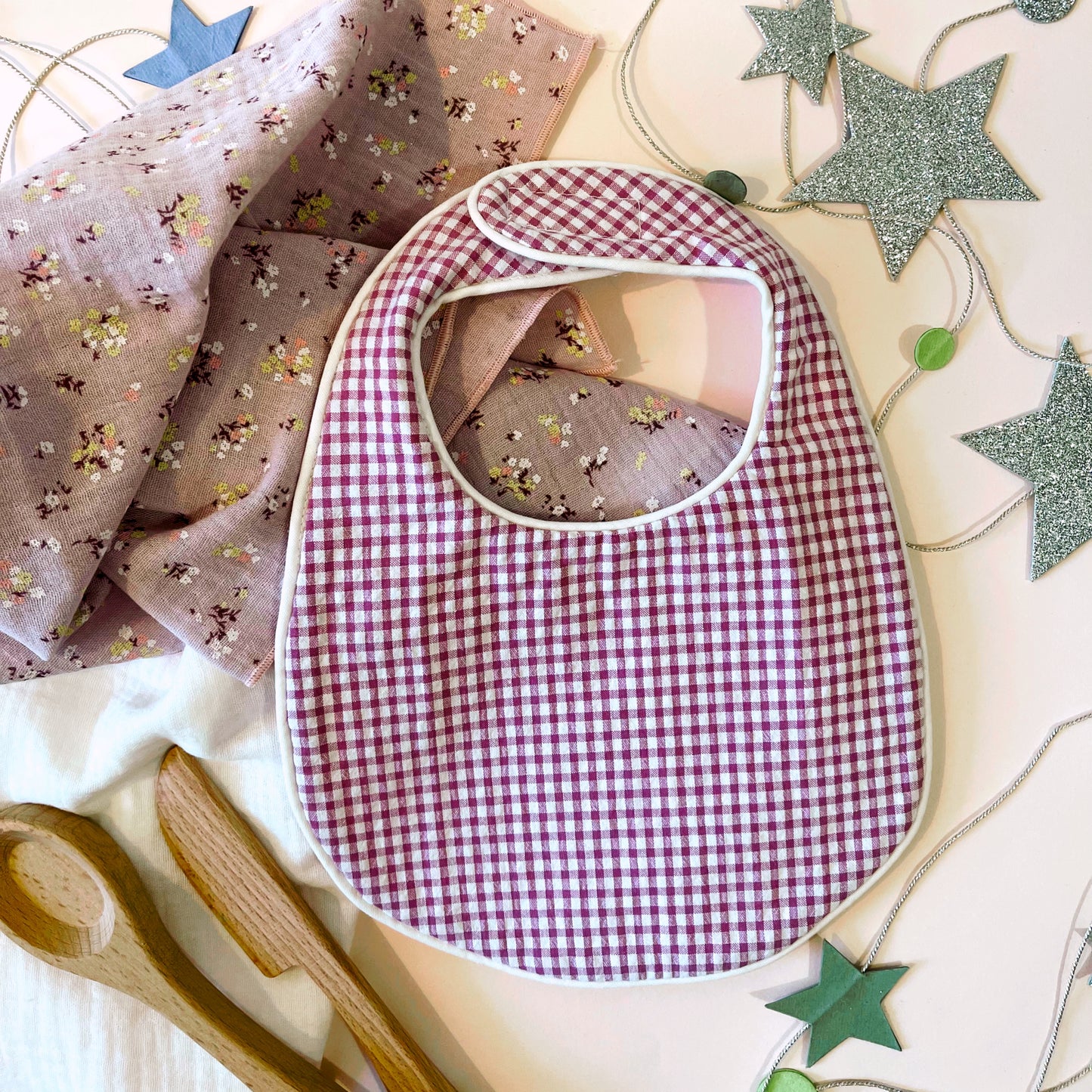 Babero  de tejido estampado cuadros rosa y blanco; muselina de color malva con flores amarillas y burdeos