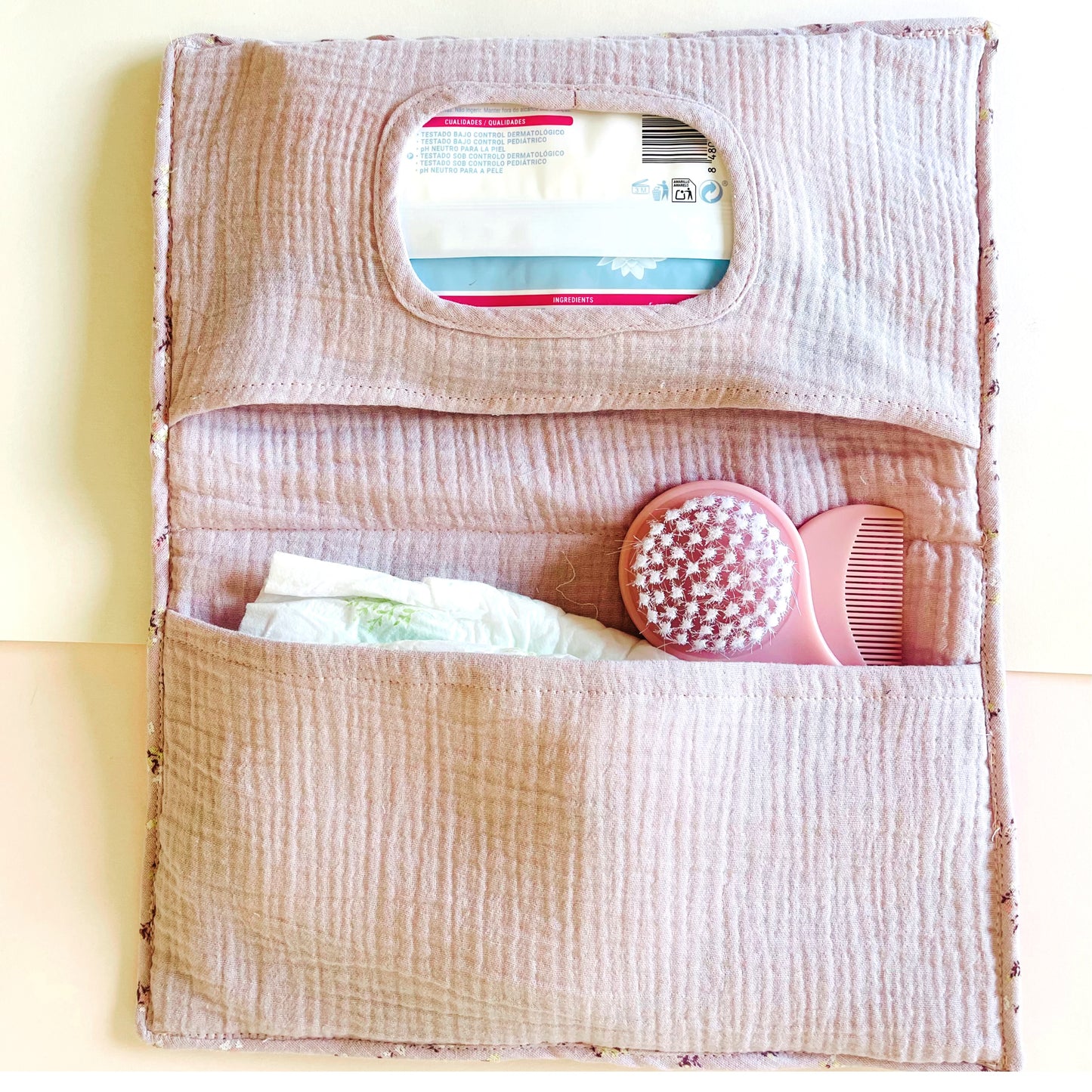 Porta toallitas abierto con dos bolsillos; el de arriba es para las toallitas y el de abajo para los pañales y los peines u otros enseres