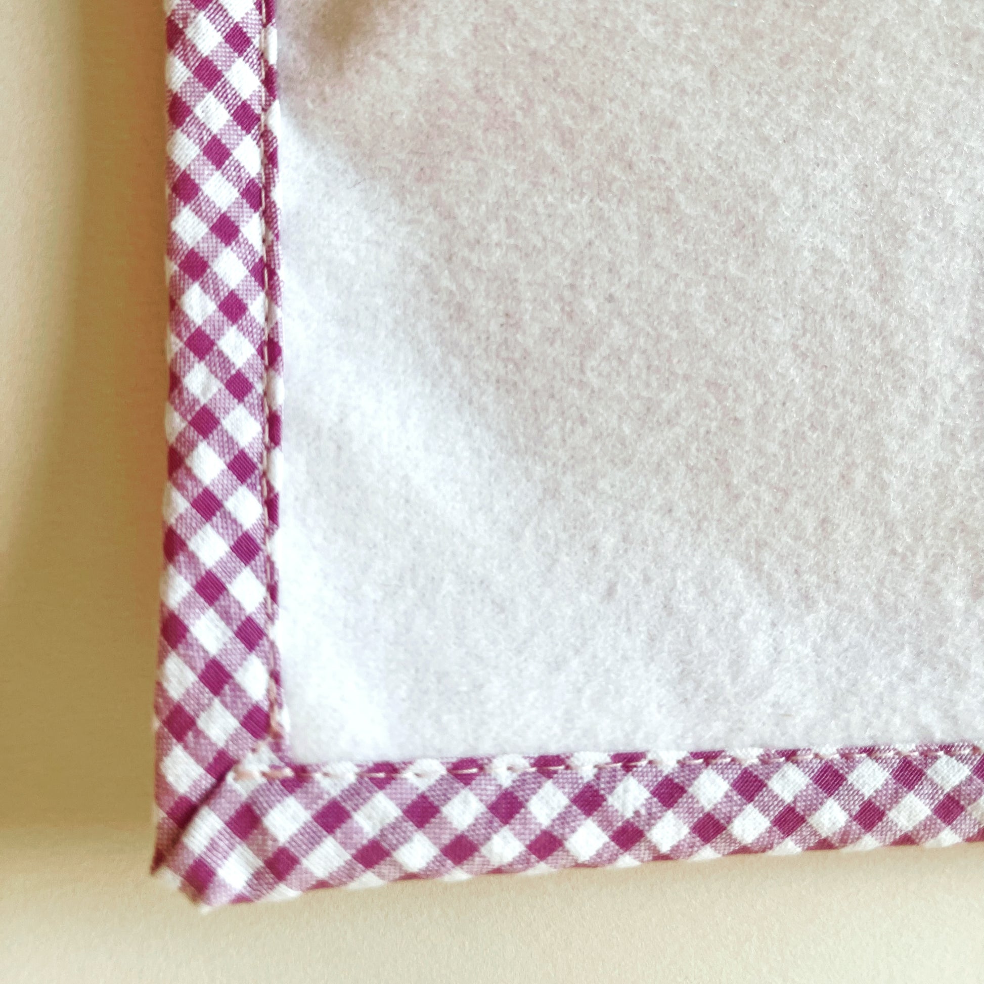 alfombra del cambiador de paseo, parte delantera de suave y delicada guata. terminación en tejido de cuadros en color rosa y blanco.