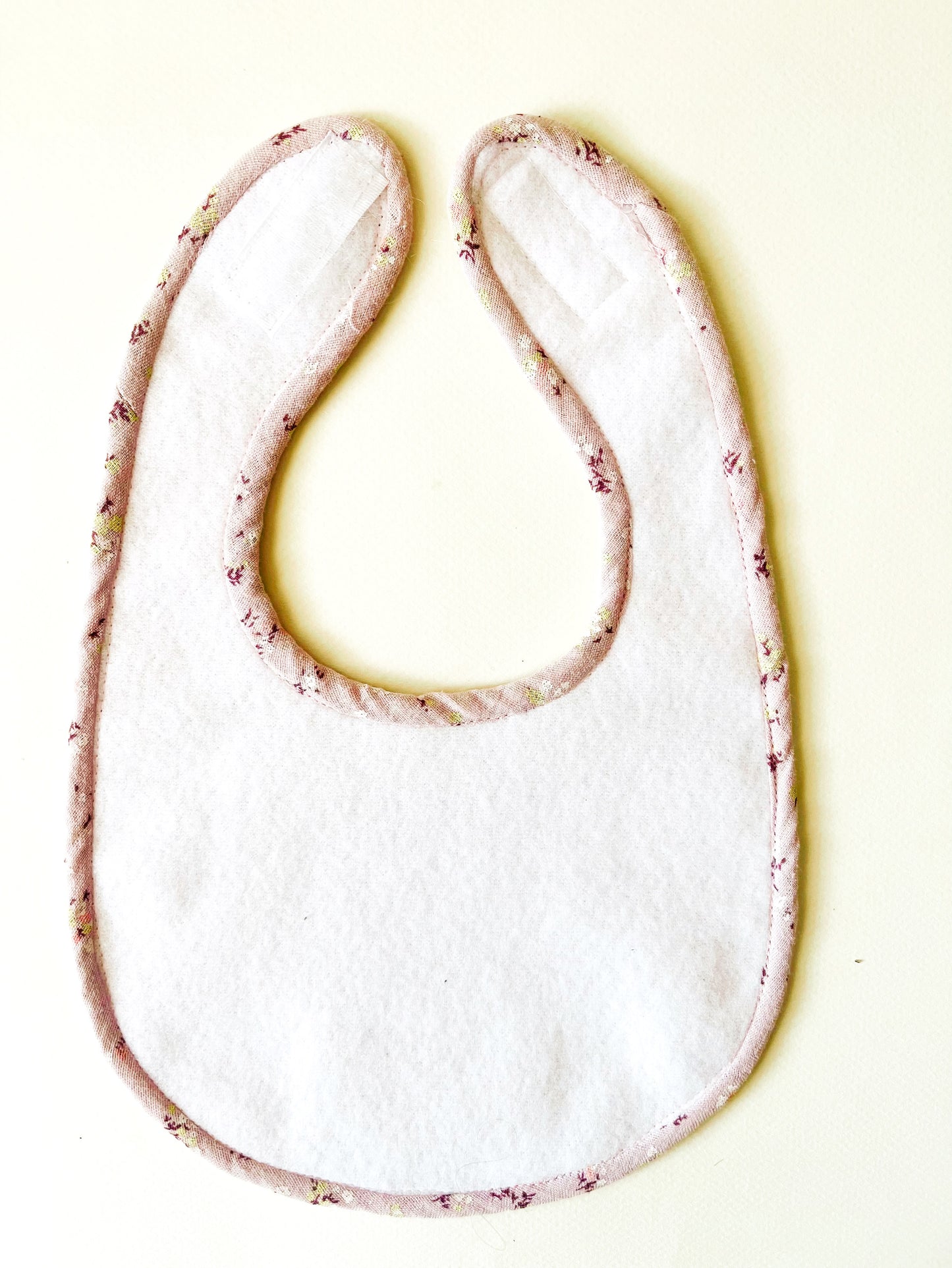 parte trasera del babero donde se aprecia la suave y delicada guata impermeable y el vibo confeccionado en la misma tela