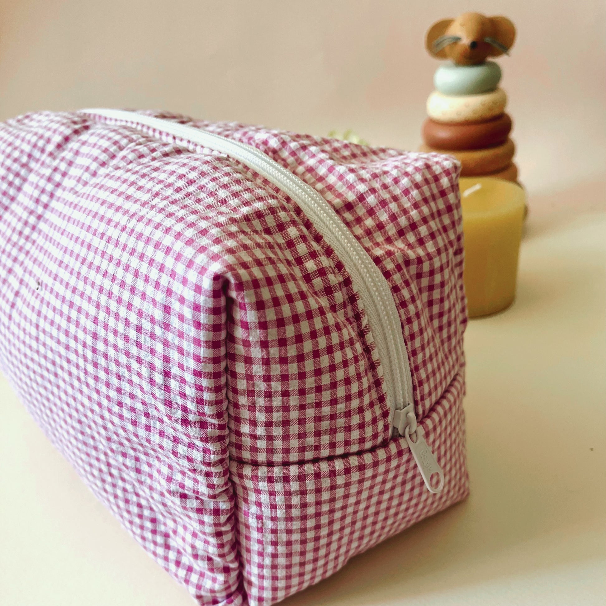 lateral del neceser en estampado de cuadros ros suave y blanco con amplia cremallera en color blanco